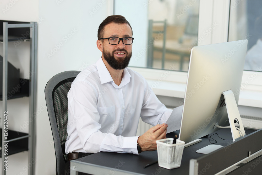 Poster technician making digital engineering drawing on computer at desk in office