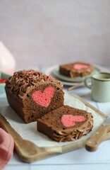 Hidden Heart Chocolate Cake. Chocolate ganache cream. Green plate and cup of coffee. Pink napkin.