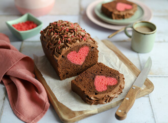 Hidden Heart Chocolate Cake. Chocolate ganache cream. Green plate and cup of coffee. Pink napkin.