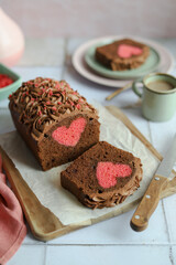 Hidden Heart Chocolate Cake. Chocolate ganache cream. Green plate and cup of coffee. Pink napkin.