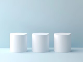 Three white cylindrical pedestals standing in a row.