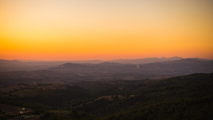 Romantic colorful sunset over the Tuscany landscape late on September when summer slowly ends is very charming and evokes calm and peaceful relaxation over a good glass of wine. Grosseto region,Italy