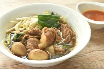 boiled braised pork meat and tendon couple organ in herb brown soup on bowl dipping spicy chili sauce 