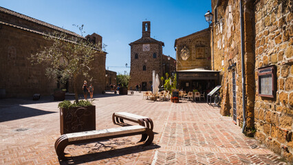 Piazze del Pretorio historical square of the ancient me dieval town of Sovana with a townhall and old stone houses during summer hot noon in Tuscany evokes relaxing vacation in Italy and slow life.