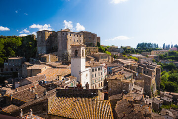 Charming view to the ancient medieval town of Sorano and its fortress with church tower and medieval terracotta houses in Tuscany, Italy evokes beautiful destination for summer italian vacation.