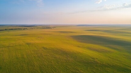 Aerial view of expansive green prairie landscape at dusk with rolling hills