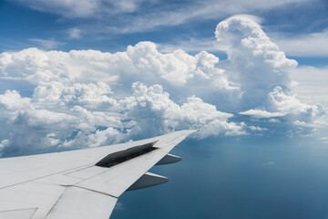 Fototapeta premium View of the plane's wing and beautiful clouds through the window during the flight.