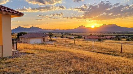 Fototapeta premium Golden Sunset Over Mountainous Landscape with Houses