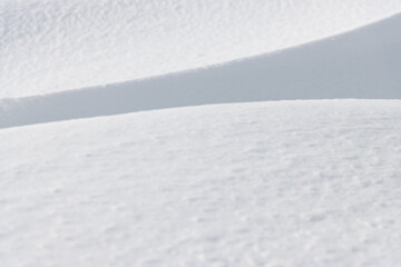 Shadow and light on sunlit fresh white winter snow surface