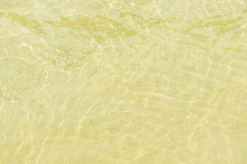 Green water with ripples on the surface. Defocus blurred transparent blue colored clear calm water surface texture with splashes and bubbles. Water waves with shining pattern texture background.