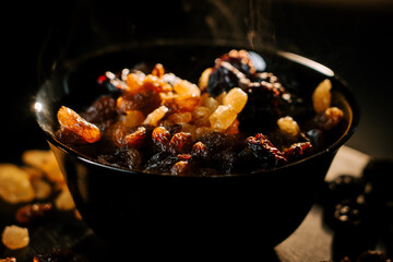 Raisin medley in black bowl with enticing steam rising in warm kitchen light