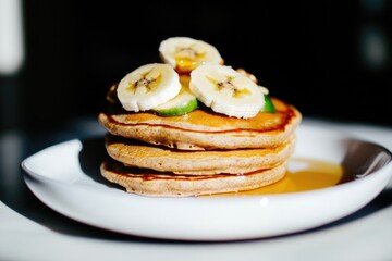 Fluffy pancakes stacked high, topped with fresh banana slices an