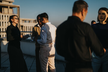 A group of multiracial colleagues engage in a brainstorming session on a high-rise balcony during...
