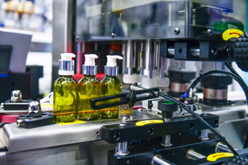 Glass bottles in a conveyor belt on a high quality automatic vertical filling machine. In the...