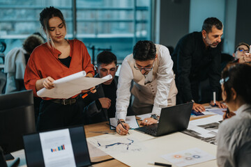 A diverse group of colleagues collaborates on project ideas at a conference table. They are analyzing data and strategizing for success in a vibrant and modern office environment.
