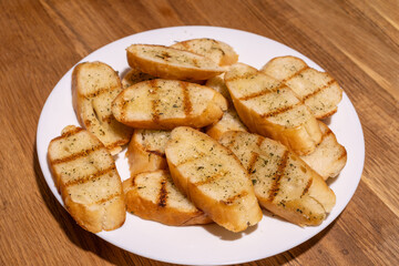 A white plate filled with several slices of garlic bread