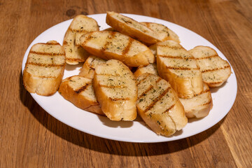 A white plate filled with several slices of garlic bread