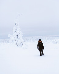 Woman hiking alone in snowy winter landscape