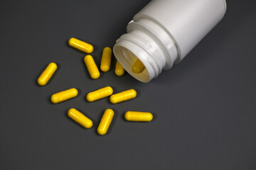 Close-up of a prescription pill bottle with capsules spilling out