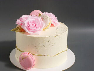 Wedding cake with white cream and decorated flowers. Sweet confection with pink roses. Pastry on a light grey background. Dessert for birthday, for Valentine's day, for Mother's day.
