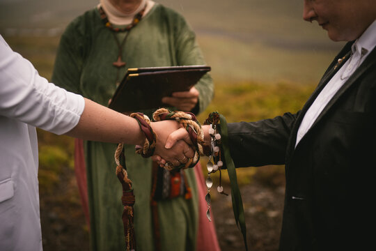 Details of a pagan handfasting ceremony with a weaved ribbon in Iceland
