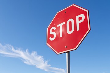 Obraz premium Octagonal Stop Sign Against a Vivid Blue Sky with Clouds