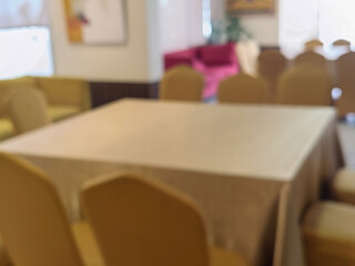 Blurred Interior View of Beige Square Tablecloth with Yellow Chair in Meeting RoomArea