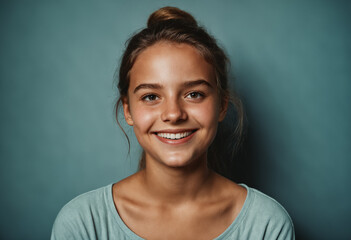 Obraz premium teenage girl smiling warmly against teal background
