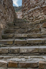 Fototapeta premium Stone staircase leads upward through ancient ruins under a cloudy sky at a historic site