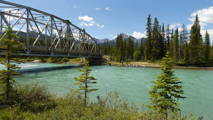 Bridge over mountain river and Caste mountain in Canadian Rockies