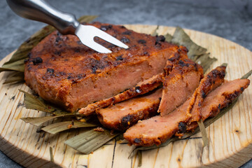 Vegan steak roasted in air fryer. Made of wheat gluten and tofu- seitan. Sliced, on wooden board, on banana leaf.