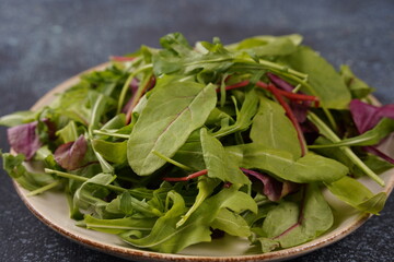 Healthy salad leaves mix in a  over dark  stone or concrete background