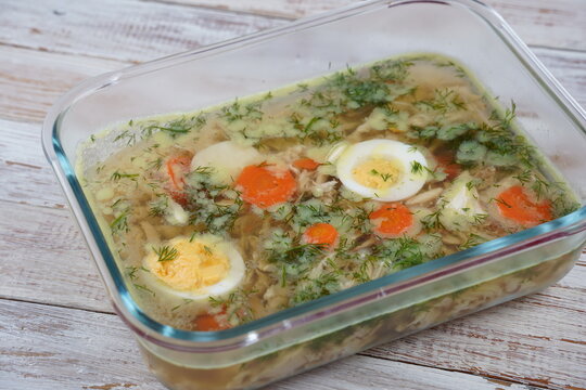 Home made aspic, jellied chicken meat with herbs and carrots. Traditional Russian dish holodets. Served with bread and mustard orand horseradish
