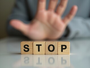 Businessman showing stop sign with hand and wooden cubes on reflective table