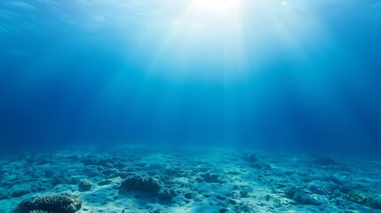 Fototapeta premium Deep Blue Ocean Background With Sunlight Rays Penetrating Calm Water Surface Underwater Scene With Sand And Rock Formations For Natural Aquatic Environment