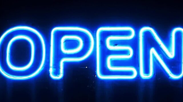 An animated lettering of the word Open in the style of a flickering neon sign on a dark background