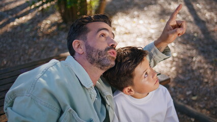 Interested father son looking distance at weekend closeup. Dad pointing finger