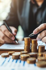 Businessman using phone to incorporate interest rate symbols such as up arrows and girls, while making stacks of coins with typography symbol check mark, placed on table in office
