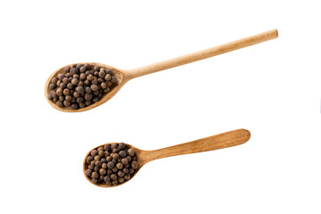 allspice or Jamaican pepper seeds in a wooden shovel isolated on white background, top view.