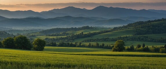 Obraz premium Serene Sunset Overrolling Hills and Mountain Range in Lush Green Landscape