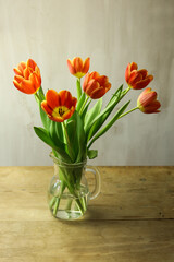 Bouquet of orange tulips on wooden table, closeup