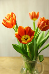 Bouquet of orange tulips on wooden table, closeup
