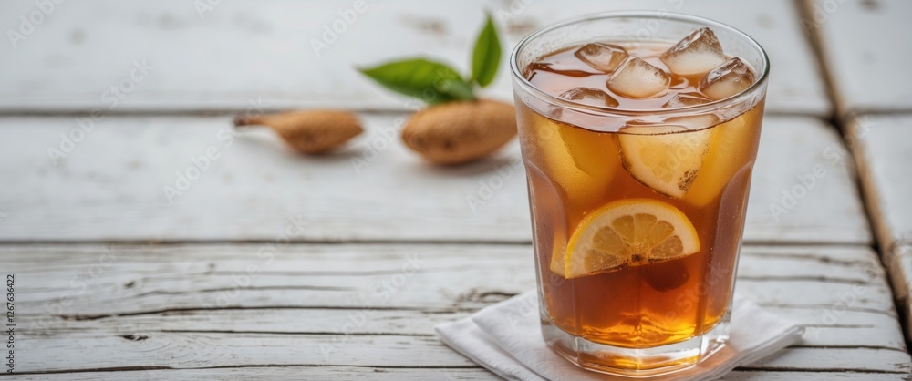 Poster refreshing iced tea with lemon slices and ice cubes served on a white wooden table with green leaf a