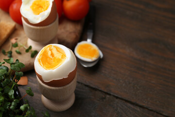 Soft boiled eggs on wooden table, closeup. Space for text