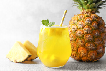 Tasty pineapple cocktail with mint in glass on gray table