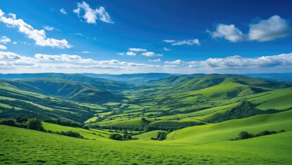 Obraz premium Lush Green Hills and Valleys Under a Vibrant Blue Sky Showcasing Nature's Beauty and Tranquility in a Scenic Landscape.