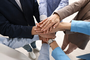 Fototapeta premium Teamwork. Group of people joining hands together indoors, above view