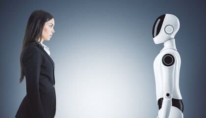 Businesswoman and humanoid robot facing each other.