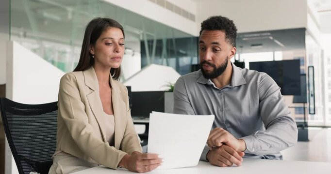 Lawyer and customer discussing paper, sitting at office table, reading document on consultation meeting. Investor consulting financial advisor, Business colleagues working on contract text
