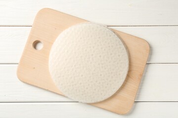 Stack of edible rice paper sheets on white wooden table, top view